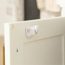 White magnetic cabinet lock latch and screws on cabinet edge for child safety