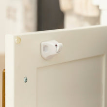 White magnetic cabinet lock latch on cabinet panel with visible mounting screw