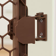 Brown plastic gate door latch close-up with mounting hardware on panel