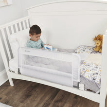 Regalo swing-down crib rail installed on white crib with mesh safety panel