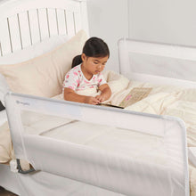 Swing-down bed rail guard with toddler reading behind clear mesh panel