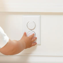White outlet safety plug inserted into wall socket with child-safety cover