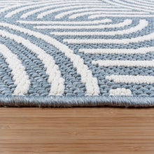Blue and white area rug edge with braided loop pile, close-up
