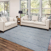 Blue area rug with white swirl wave pattern, flat on hardwood floor