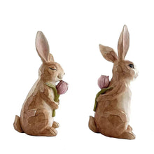 Resin bunny figurines set of 2, angled views holding pink tulip flowers with stems