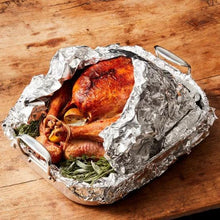 Aluminum foil packet with roasted chicken and herbs, open seam visible
