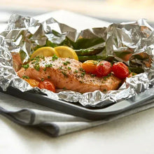 Aluminum foil packet with baked chicken, tomatoes, and herbs