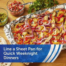 Sheet pan lined with aluminum foil holding roasted chicken, peppers, and onions