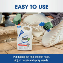 Weed killer container with hose hookup, blue trigger sprayer nozzle near ground