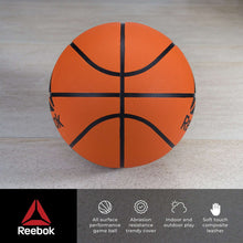 Orange outdoor basketball with black cross seams and Reebok branding on textured rubber