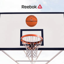 Orange Reebok basketball above hoop with black seam lines