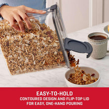 Cereal storage container with dark gray flip-top lid being poured by hand