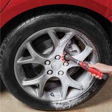 Power scrubber with red bristle head cleaning a metal wheel rim