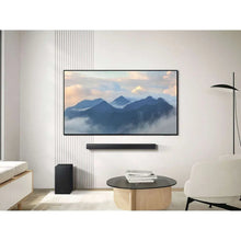 Black soundbar under TV with matching black subwoofer speaker