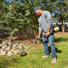 Gas string trimmer in use on a lawn, trimmer head held near the ground
