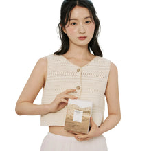 Person holding Centella ampoule box with amber bottles