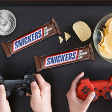 SNICKERS ice cream bars with peanut pieces and chocolate coating on a dark surface