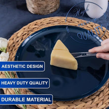 Clear disposable knife and fork on a navy plate with a decorative cheese wedge