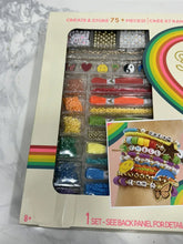 Rainbow jewelry studio kit package with bead trays, chains, and charm cards