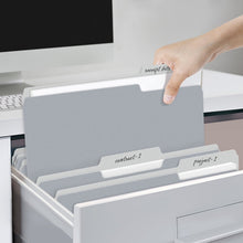 Person placing light gray file folders with 1/3 cut tabs into a storage drawer