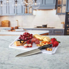 Snacklebox cutting board lid with assorted cheese and fruit, plus knife