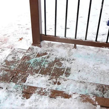 Ice melt on snowy brick walkway beside metal fence rails