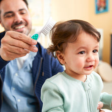 Baby hair brush and fine-tooth comb being used for toddler hair grooming