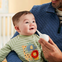 Baby health kit tool with white tip held to baby’s mouth by caregiver