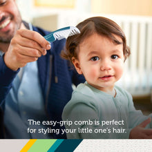 Teal baby grooming comb held to infant hair