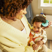 Safety 1st blue grooming brush held by caregiver for baby's hair