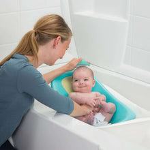 Aqua cradle cap brush being used for baby bath time grooming
