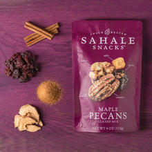Maple pecans glazed snack mix bag with nut pieces and cinnamon sticks on surface