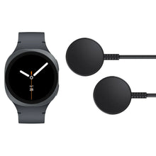 Smartwatch with dark gray silicone band and two wireless fast chargers, round pads