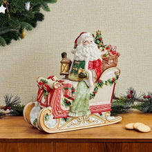 Holiday cookie jar with Santa on sleigh carrying lantern and gift, red green holly trim.