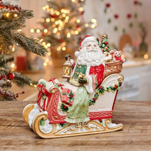 Holiday cookie jar with Santa on decorated sleigh, lantern and gifts, red and green accents.