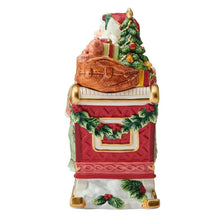 Holiday cookie jar with Santa backing view on base, holding tree and bag of gifts.