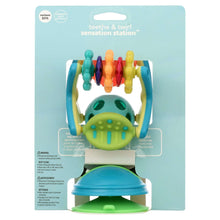 Retail package showing teal sensory station toy with multicolor spinning rollers