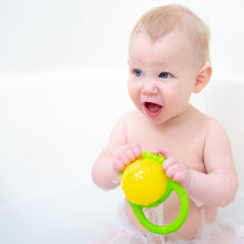 Infant bath toy cup with green handle and yellow top held by baby