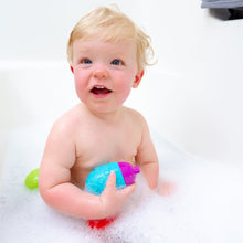 Infant bath toy scoop cups in blue and pink held by a smiling baby