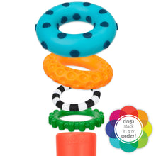 Stacking ring toy rings in teal polka dot, orange, black-and-white stripe, green base