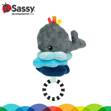 Grey whale plush sensory toy with colorful ribbon tags and hanging black-white ring