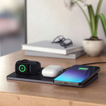 Wireless charging station on desk with smartwatch dock, white earbuds, and phone charging pad