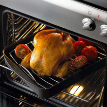 Roasting pan holding whole chicken and vegetables inside oven