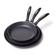 Set of 3 nonstick French skillets with black handles, nested in graduated sizes.