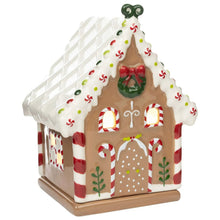 Gingerbread-style ceramic wax warmer with white roof, red doors, and green wreath detail