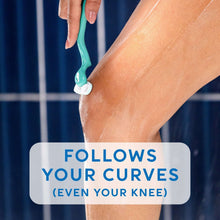 Teal razor shaving a forearm with shaving lather under a hand