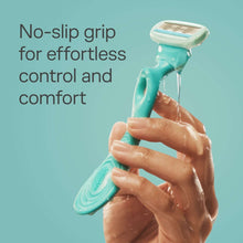 Woman’s hands holding a turquoise razor under running water