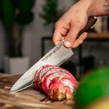 Chef knife held in hand, slicing a rolled vegetable on a cutting board