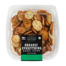 Organic everything bagel chips in clear plastic tub, seeded slices visible