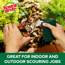 Green heavy-duty scour pad in hand for outdoor cleaning